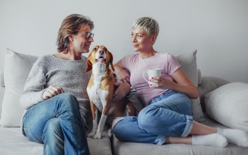a couple of women sitting on a couch with a dog
