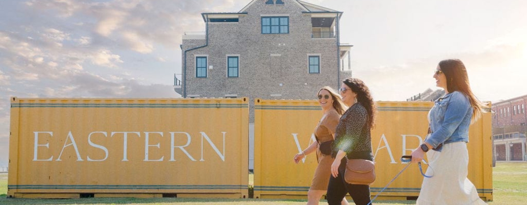 group of women and dog walking by Eastern Wharf containers
